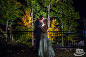 The couple shared a romantic evening kiss on their wedding day. As the sun set on their special day, the wedding couple stole a sweet kiss.