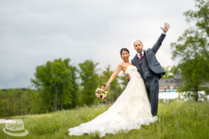 The couple waves joyously at the golf course on their special day The happy couple is cheerfully waving at a golf course on their wedding day.